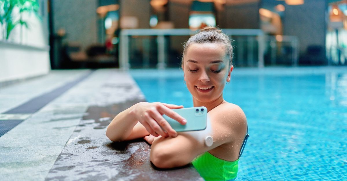 Smiling woman wearing a wearable medical device on her arm, secured with skin-safe adhesives for comfort and durability.